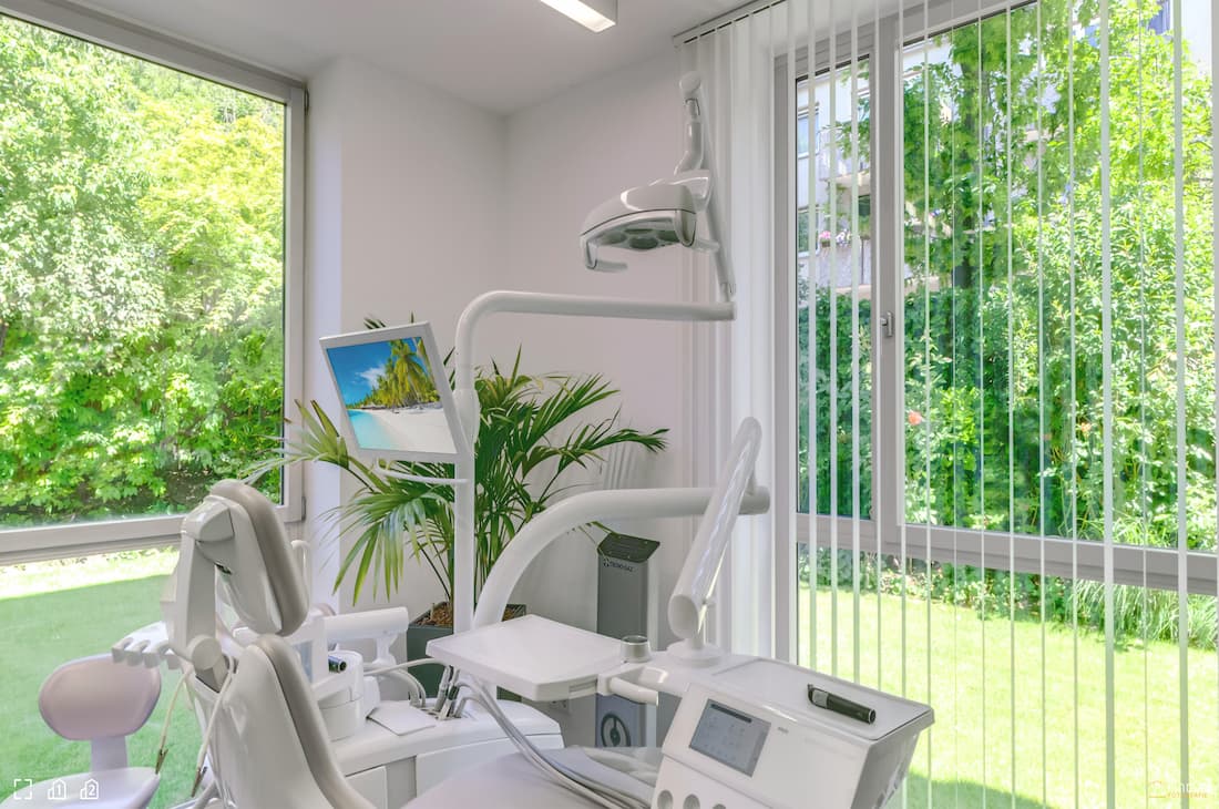 Beruhigendes Behandlungszimmer bei Carree Dental in Köln mit Blick in die Natur des Gartens der Zahnarztpraxis