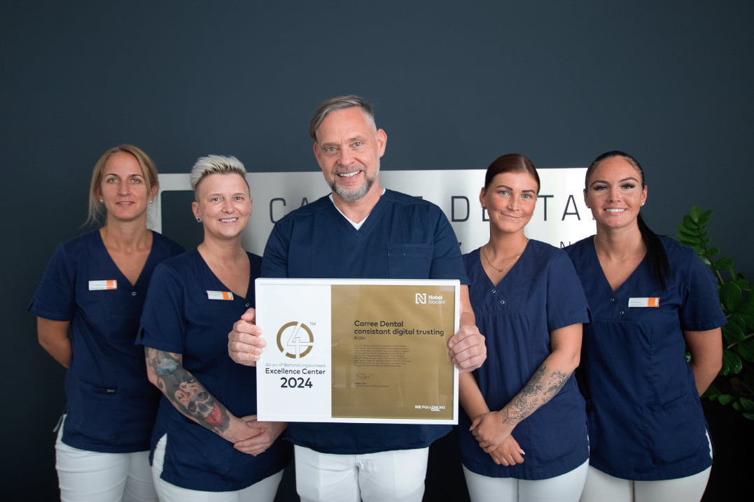 Das Team von Implantologe Dr. Schmidt hält das neuste Zertifikat von Nobel Biocare in den Händen, als Center of Excellence für das All on 4 Verfahren